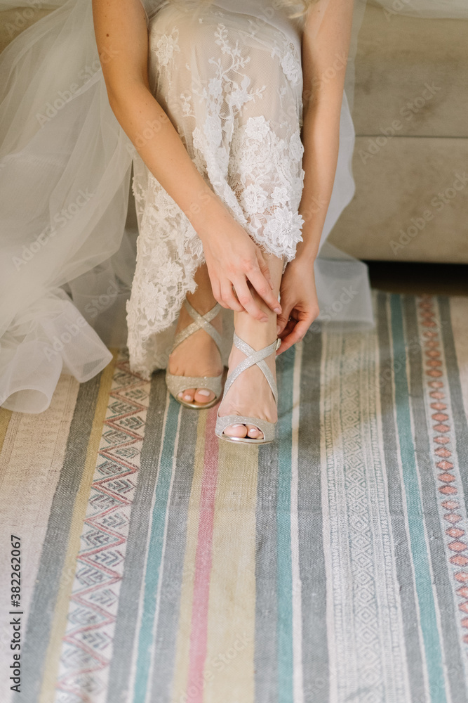 Bride putting on elegant heels for her wedding Bride putting on elegant heels for her wedding