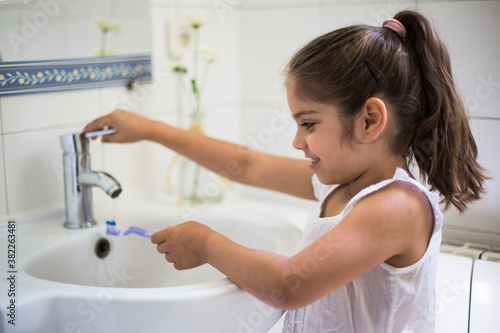 Girl brushing teeth in bathroom photo