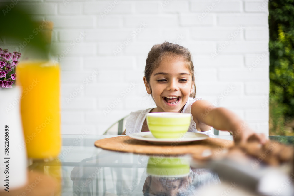 Cute small girl stretching for food Cute small girl stretching for food