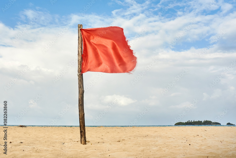 © Per Swantesson/Stocksy - Red warning flag on beach © Per Swantesson/Stocksy - Red warning flag on beach
