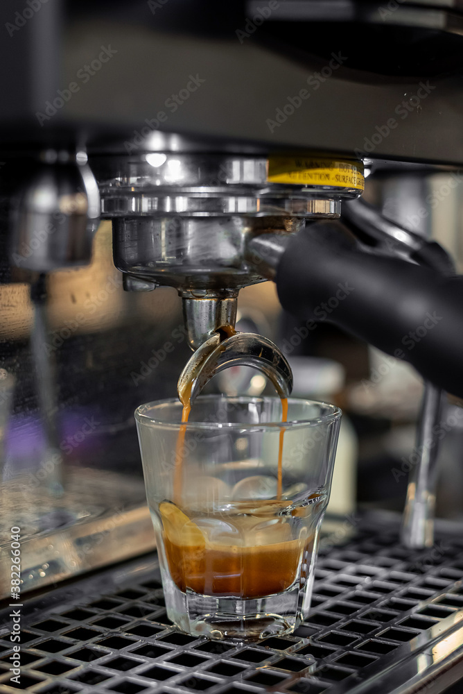 Espresso machine pouring shot into glass cup Espresso machine pouring shot into glass cup