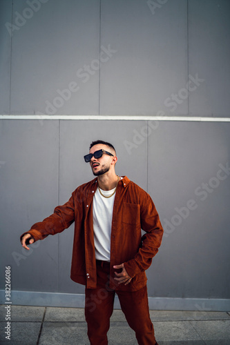 Chico con conjunto de pana rojo posando delante de pared gris en cadiz