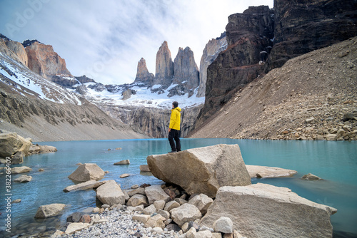 Hiker gazing the views of a blue lagoon in the base of the Towers in Torres del Paine National Park, Chile photo