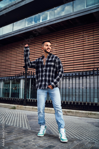 Wallpaper Mural Chico joven con camisa de cuadros posando de forma alegre Torontodigital.ca