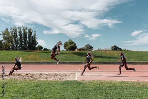 Stages of black sportswoman jumping into sandpit