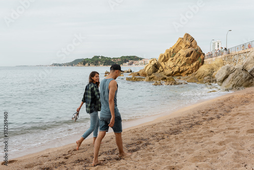 Young couple walking and talking on beach photo