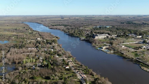 Video desde un dron con vista panorámica, volando en las afueras de un pueblo con un río., hacia un río.  photo