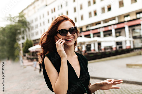 Portrait of lady in sunglasses talking on phone