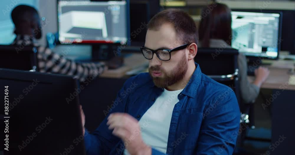 Close up of young handsome caucasian man with beard in glasses in denim shirt tired sitting long at work. Male takes off his glasses and wipes his eyes. Close up of young handsome caucasian man with beard in glasses in denim shirt tired sitting long at work. Male takes off his glasses and wipes his eyes.