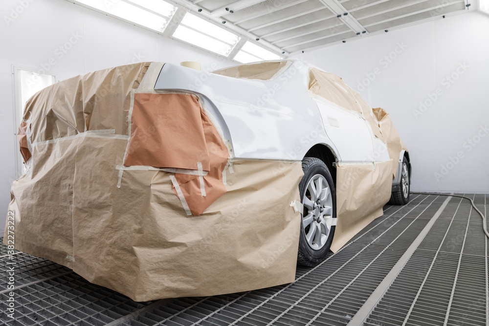 White car covered with paper in garage White car covered with paper in garage