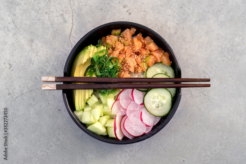 Raw fish and vegetables poke bowl photo