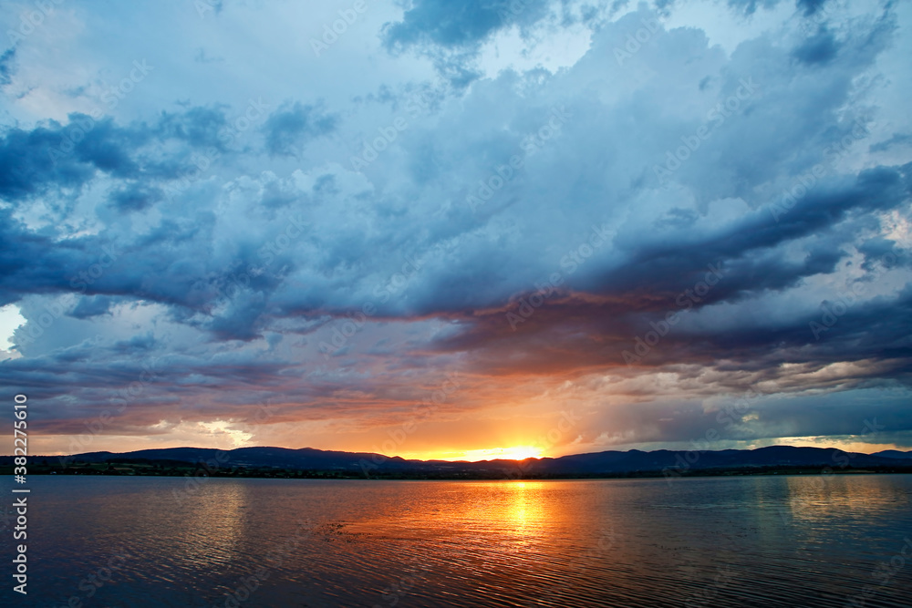 Obraz premium Dramatic clouds over the lake. Sunset. Storm.