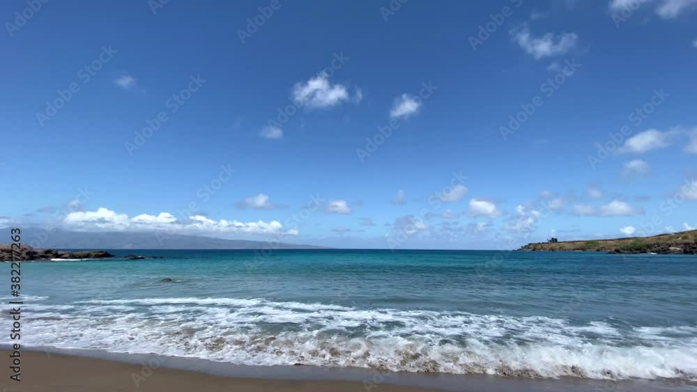 Mokulei'a Beach in Maui, Hawaii with gentle waves across golden sand Mokulei'a Beach in Maui, Hawaii with gentle waves across golden sand