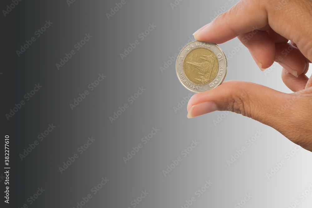 Fototapeta premium hand holding coin on blur image for inflation or failing, going bankrupt. finance concept.