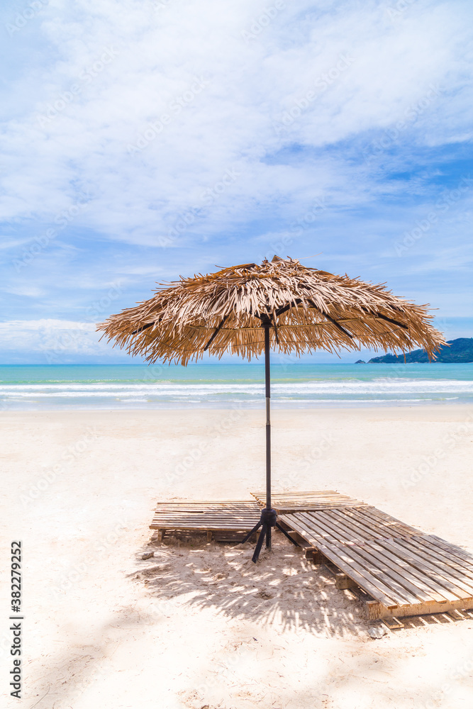 Beach Umbrella made of palm leafs on a perfect white beach in front of Sea in Thailand.