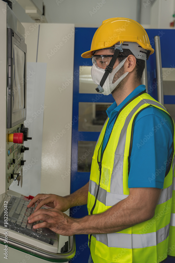 factory worker with face mask working at factory control panel factory worker with face mask working at factory control panel