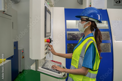 factory tecnician with face mask working in factory control room photo