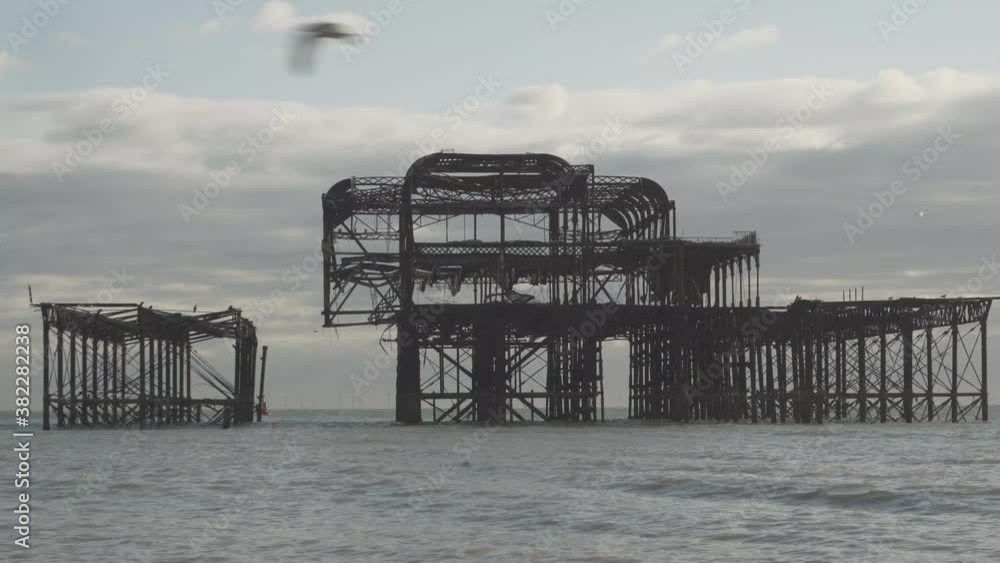 famous burnt pier in brighton city england uk. calm sea and some clouds in the sky famous burnt pier in brighton city england uk. calm sea and some clouds in the sky