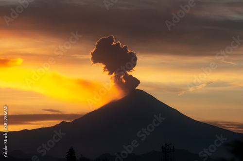 Amanecer sobre el volcán Popocatepetl, fumarola y nubes.