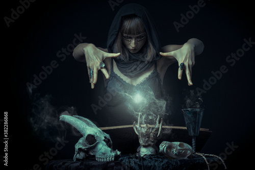 Fotobehang Dark sorceress casting a magic spell with a human skull