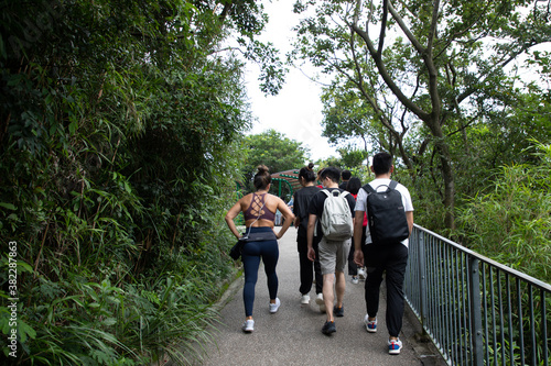 young men, women or boys and girls, university students with face masks hiking along trails in Victoria Peak, Hong Kong during covid-19 © James Jiao