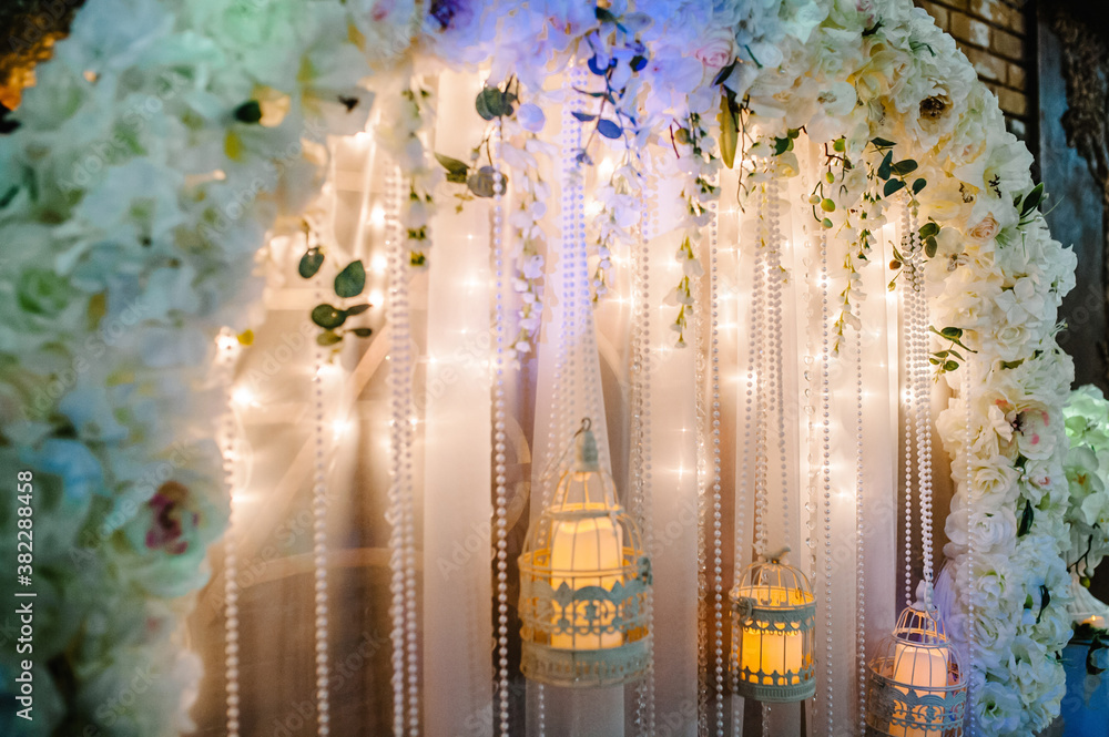 Arch for wedding area a is decorated with white flowers and greenery ...