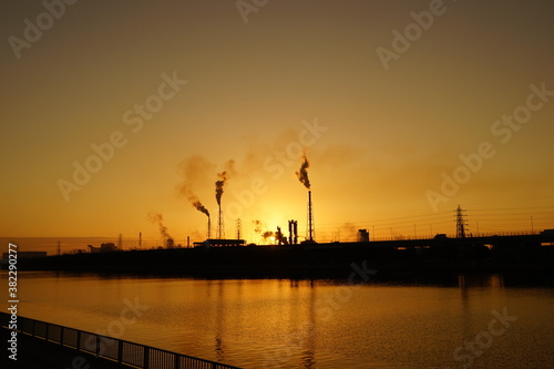 工業地帯のシルエットの夕景と運河