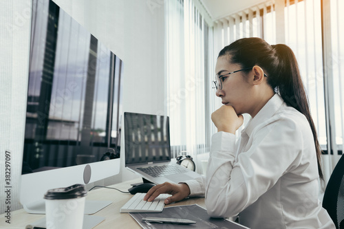 Asian female software developer is worried about analyzing code-based systems at his office. © wutzkoh