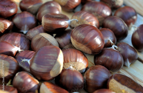 close on a group of sweet fresh chestnuts on a plank