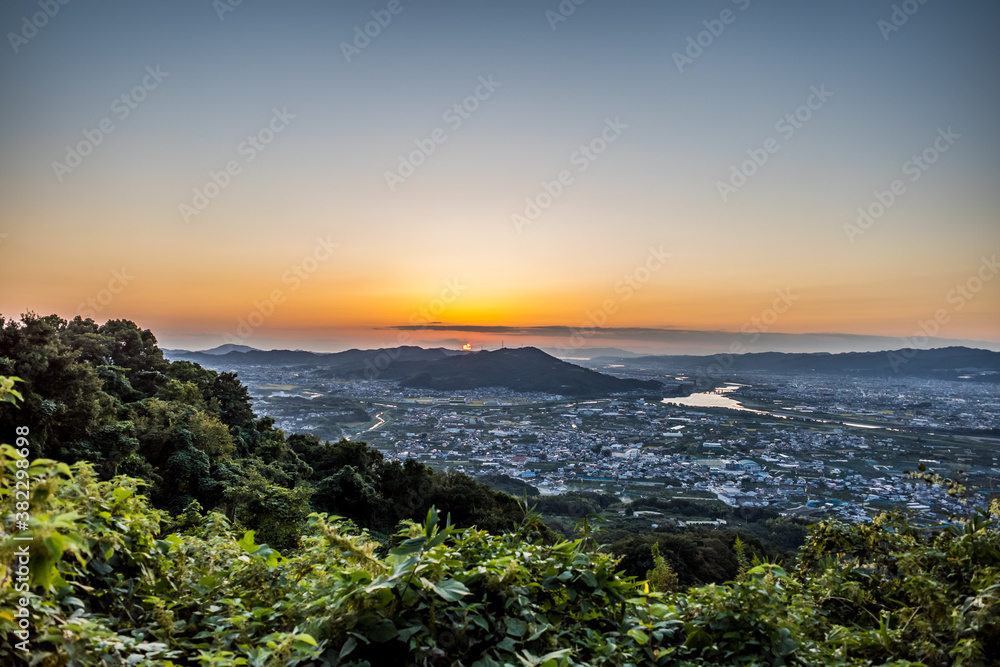 和歌山県紀の川市の百合山から見える和歌山港に沈む夕日。秋、10月。