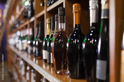 Racks with red and white wine bottles in large wine store