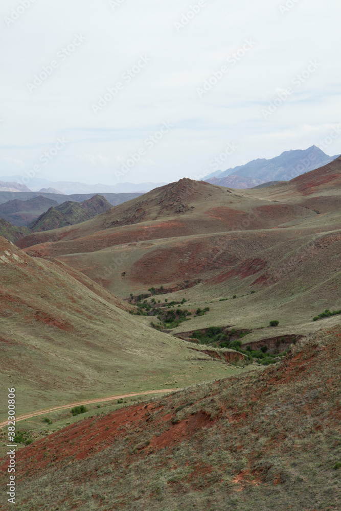 Enchanted valley in Salta, Argentina. View of the grassland, hills, valley and dirt path across the green field. 