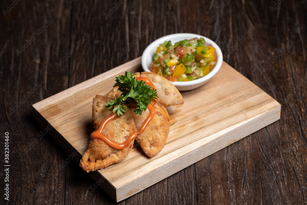 Traditional Spanish tapas with tomatoes, greens and tomato sauces on the wood plate board. Fried meat pies. Fish, seafood. High quality photo. Traditional Spanish tapas with tomatoes, greens and tomato sauces on the wood plate board. Fried meat pies. Fish, seafood. High quality photo.