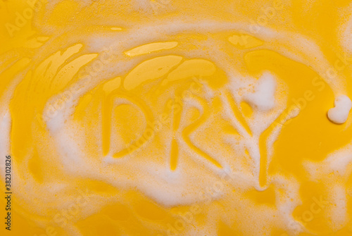  the word DRY written in foam on a yellow background. photo