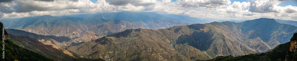 Impressive panorama of mountains  and Chicamocha canyon with white clouds from Monument of the Virgin Mary at Chicamocha National Park, Colombia