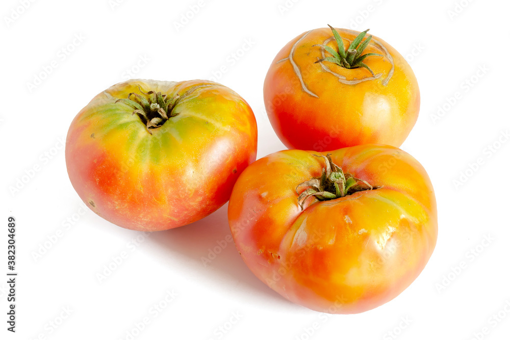Three ripe yellow tomatoes on a white background. Three ripe yellow tomatoes on a white background.