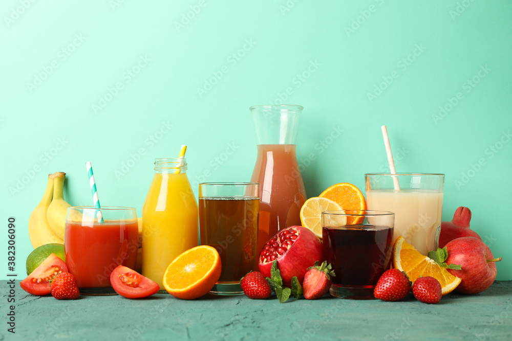 Concept of glasses and bottles with different juices on green background Concept of glasses and bottles with different juices on green background