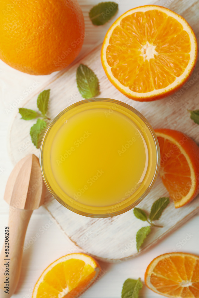 Board with glass of orange juice, oranges and juicer on wooden background Board with glass of orange juice, oranges and juicer on wooden background