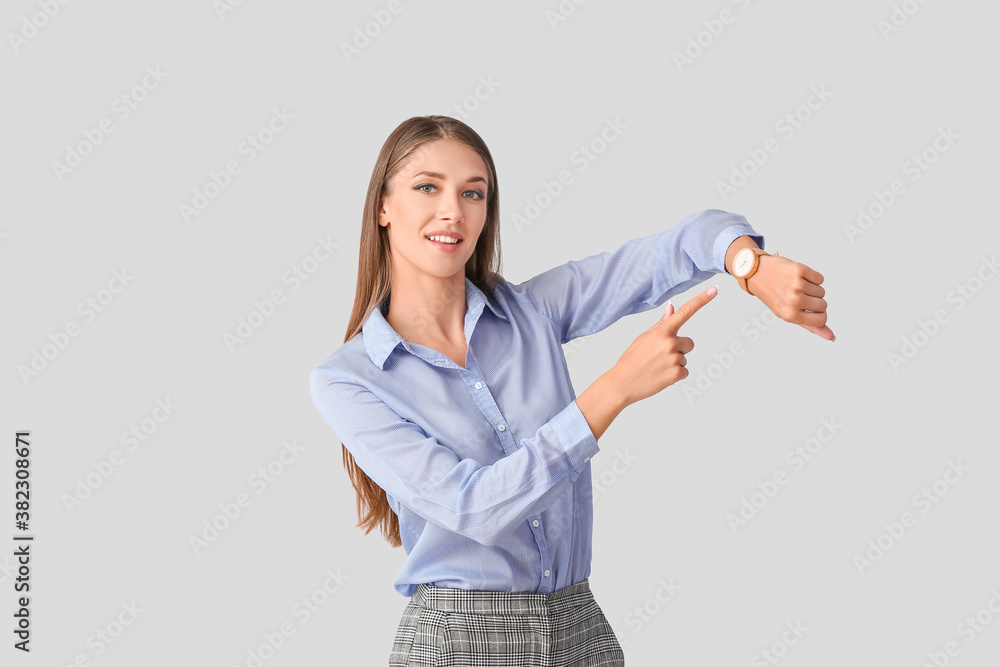 Young woman with wristwatch on light background Young woman with wristwatch on light background