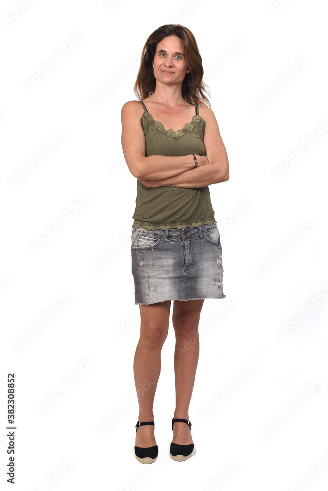 front view of the full portrait of a woman in a denim skirt on white background, arms crossed front view of the full portrait of a woman in a denim skirt on white background, arms crossed