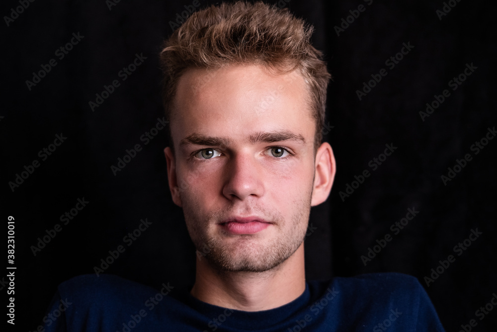 Portrait of a serious  handsome young guy on a dark background