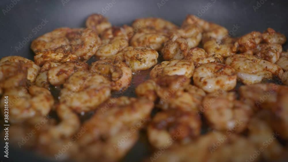 Extreme close-up of seasoned shrimp frying in a pan. Extreme close-up of seasoned shrimp frying in a pan.