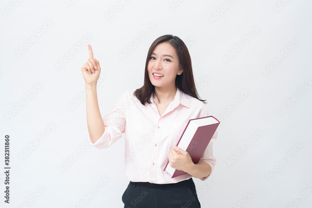 portrait of beautiful woman student in pink shirt is holding a book isolated over white background studio portrait of beautiful woman student in pink shirt is holding a book isolated over white background studio