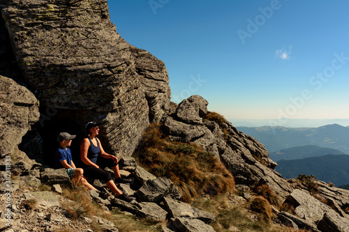 Family on one of the peaks of the Ukrainian Carpathians, parents and children admire the views of the Carpathians from Mount Smotrych, the Montenegrin ridge, rocky peaks in the Carpathians. photo