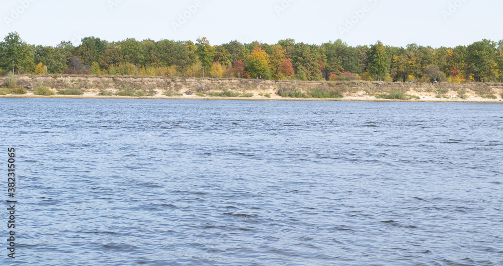 Oka river,far high Bank with trees of different colors.