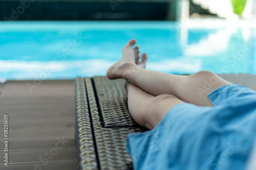 Woman lounging and chilling near the pool at an outdoor resort on a relaxing vacation. Pool ,vacations and Summer Concept © Shisu_ka
