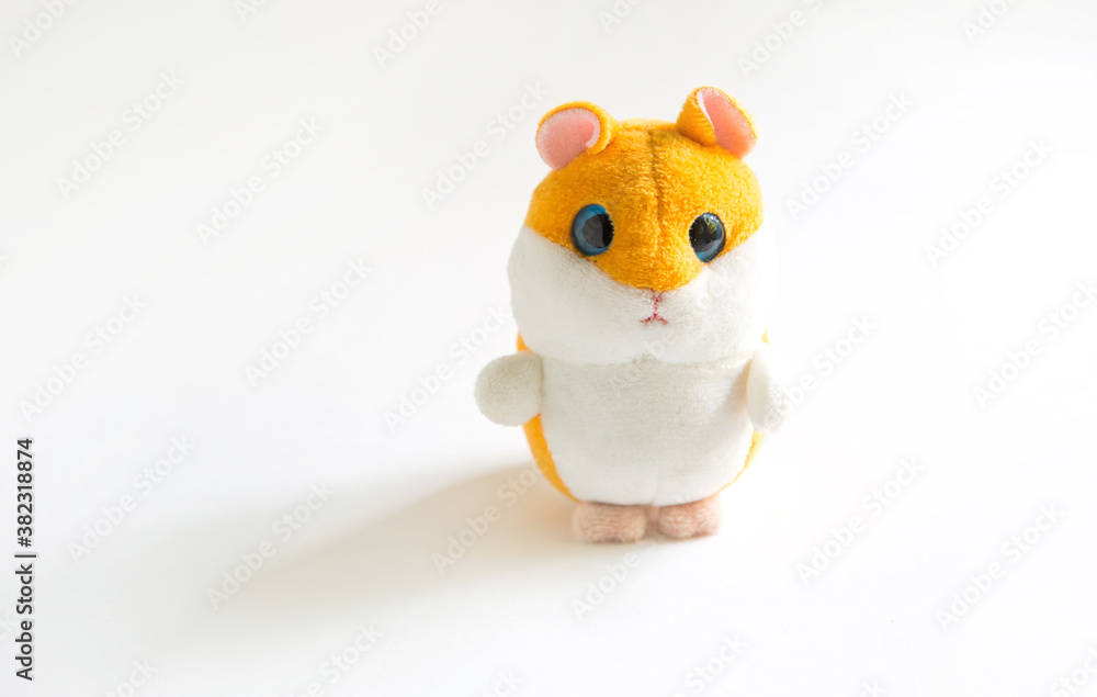 Soft plush toy hamster with orange head and white belly on a gray background. Children's toy close-up, space for text Soft plush toy hamster with orange head and white belly on a gray background. Children's toy close-up, space for text