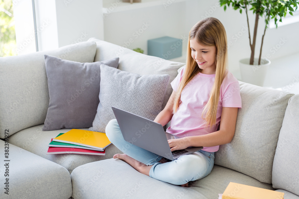 Top above high angle view full size photo of positive smart kid girl study remote use laptop watch educational video sit divan in house indoors Top above high angle view full size photo of positive smart kid girl study remote use laptop watch educational video sit divan in house indoors