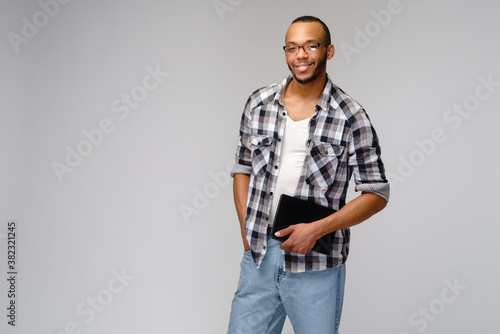 Portrait of a young african american man wearing green t-shirt holding tablet pc pad