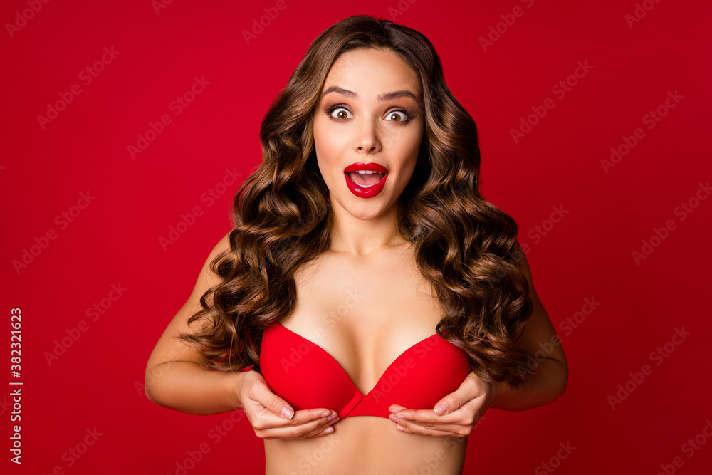 Photo of attractive shocked lady bright lipstick arms hold unbelievable big  breast amazing bra push up effect open mouth wear brassiere isolated vivid  red color background Stock Photo